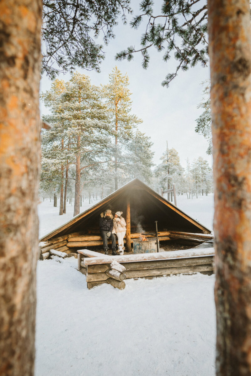 couple in laavu during proposal in Finnish Lapland near Rovaniemi